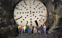 Construction workers standing in the massive underground stormwater tunnel under Providence.
